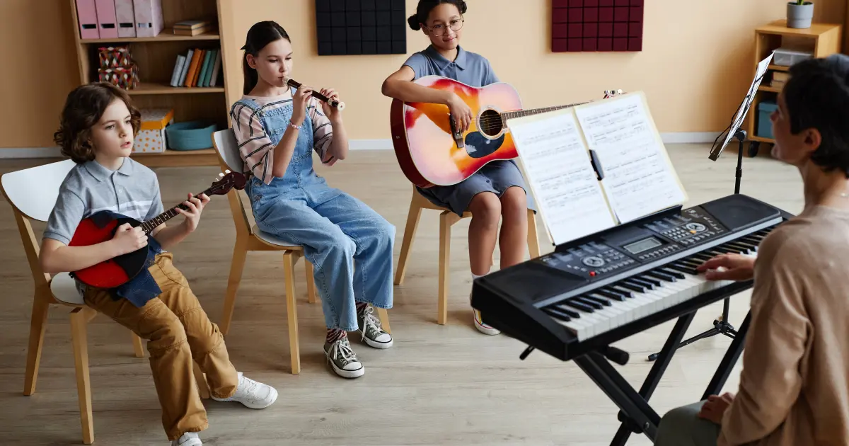 Copii care canta la diferite instrumente muzicale, intr-o sala a unei scoli de muzica